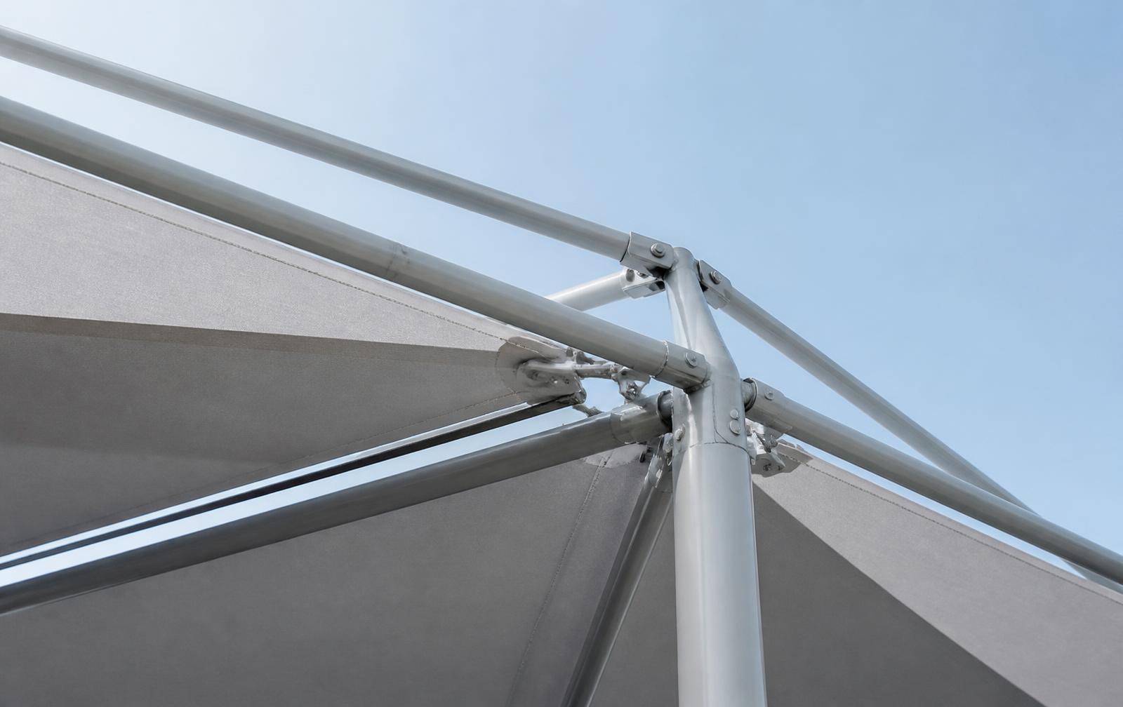 Aluminium and fabric canopy structure detail against a clear sky